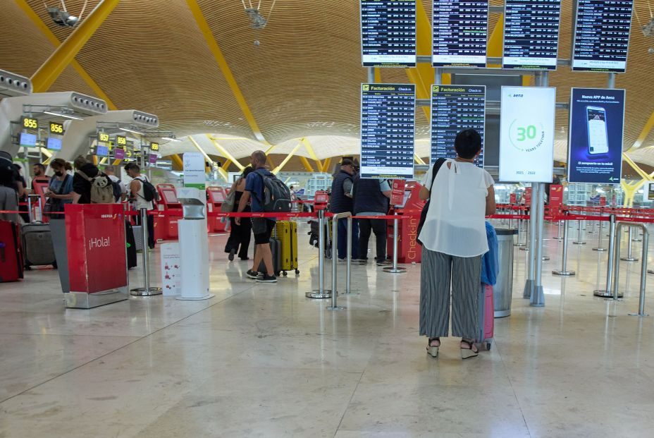 EuropaPress 4570608 paneles varias personas hacen cola terminal t4 aeropuerto adolfo suarez