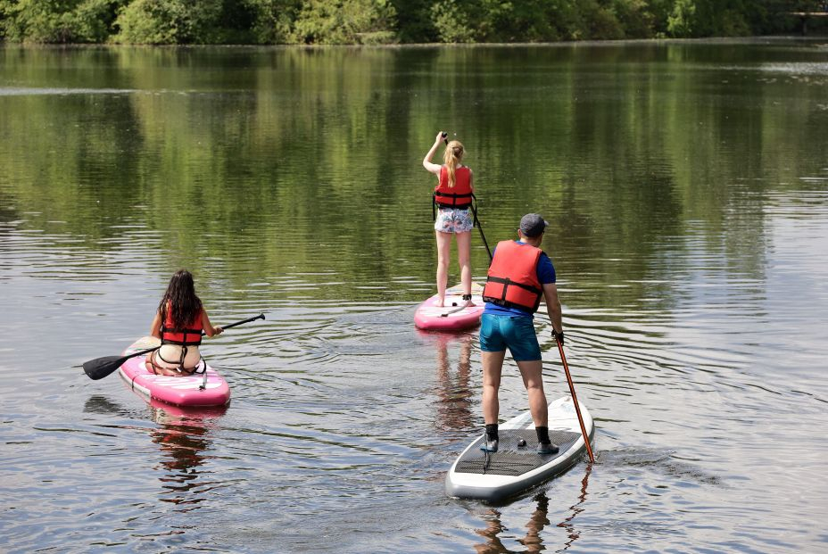 bigstock Sup Surfing Man And Two Girls 455994415