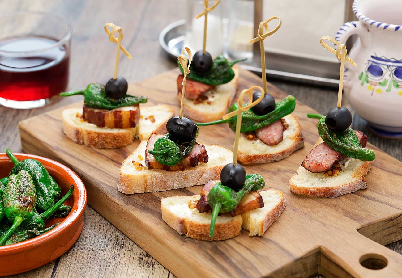 Tapa de panceta con pimiento del padrón y aceituna negra. Foto: Bigstock