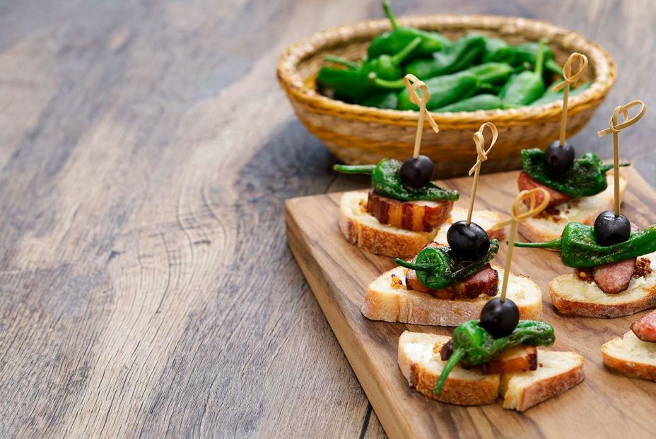 Tapa de panceta con pimiento del padrón y aceituna negra. Foto: Bigstock