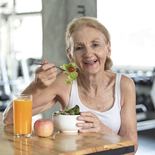 Mujer mayor comiendo verduras