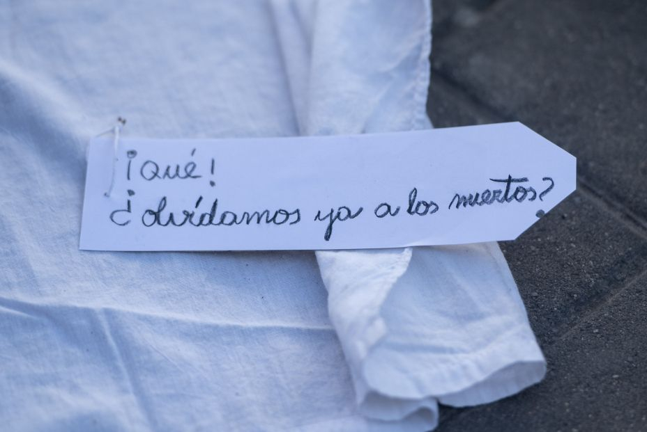 Un letrero que reza '¡Qué! ¿Olvidamos ya a los muertos?' en una ‘performance’, de Marea de Residencias y Verdad y Justicia