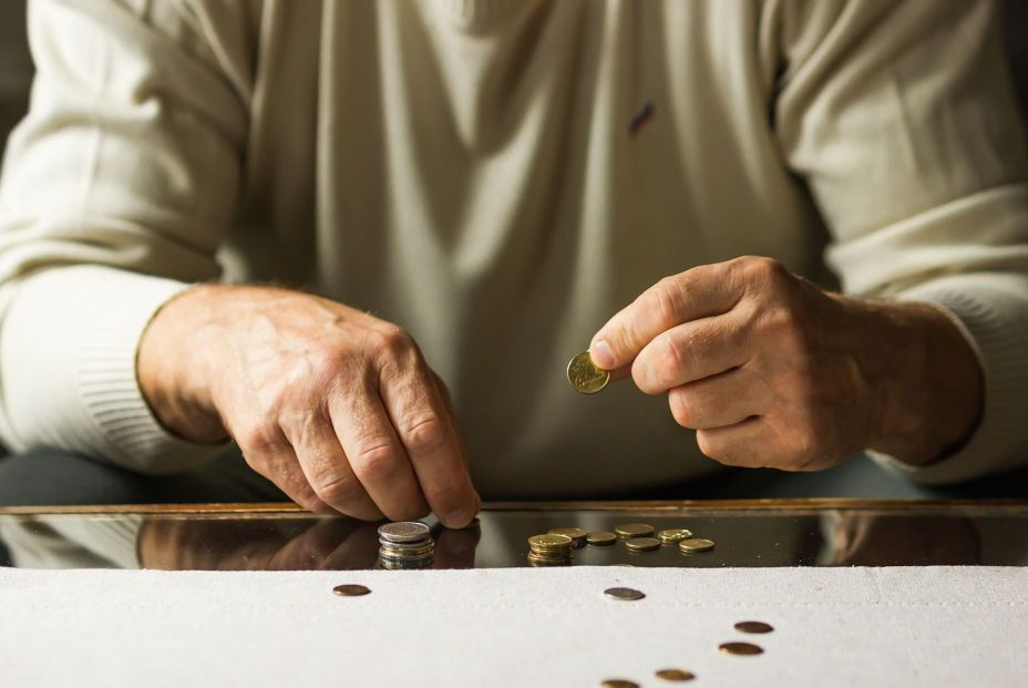 bigstock Senior Man Counting Coins On T 464311457