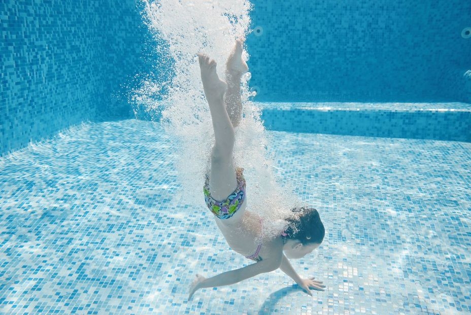 Niño salta hasta el fondo de la piscina