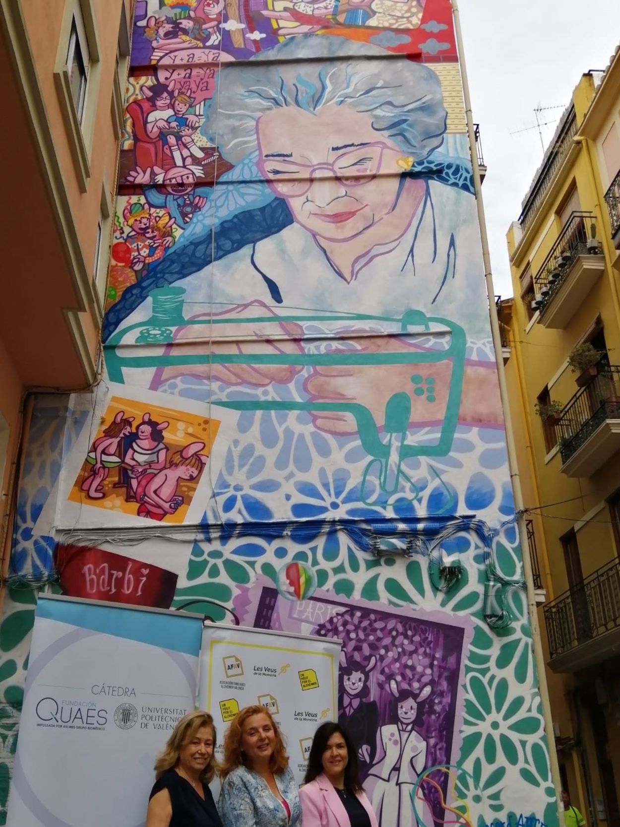 Una mural de una mujer mayor cosiendo rinde homenaje a todos los enfermos de alzhéimer en Valencia