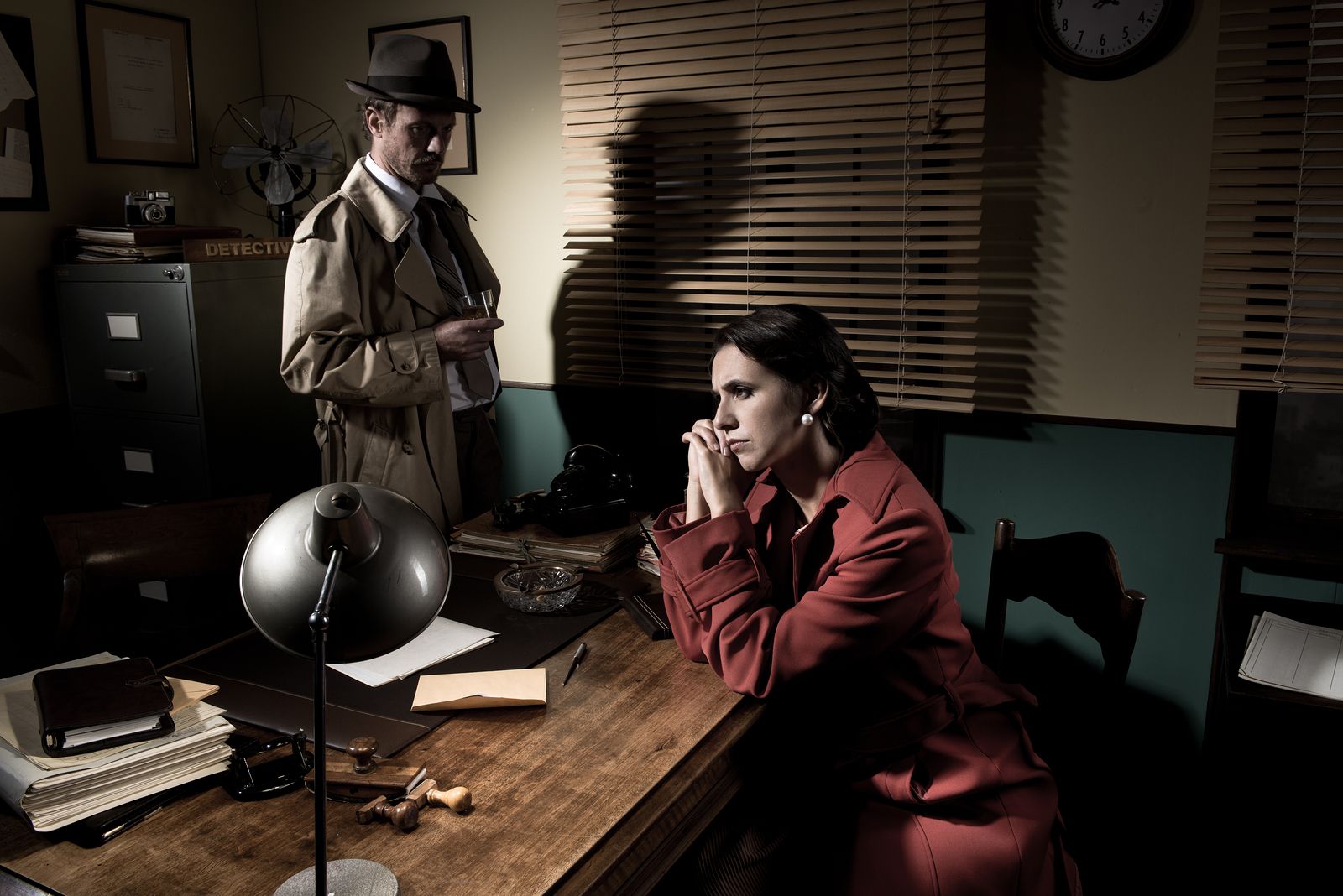 Escena noir de detective interrogando (BigStock)