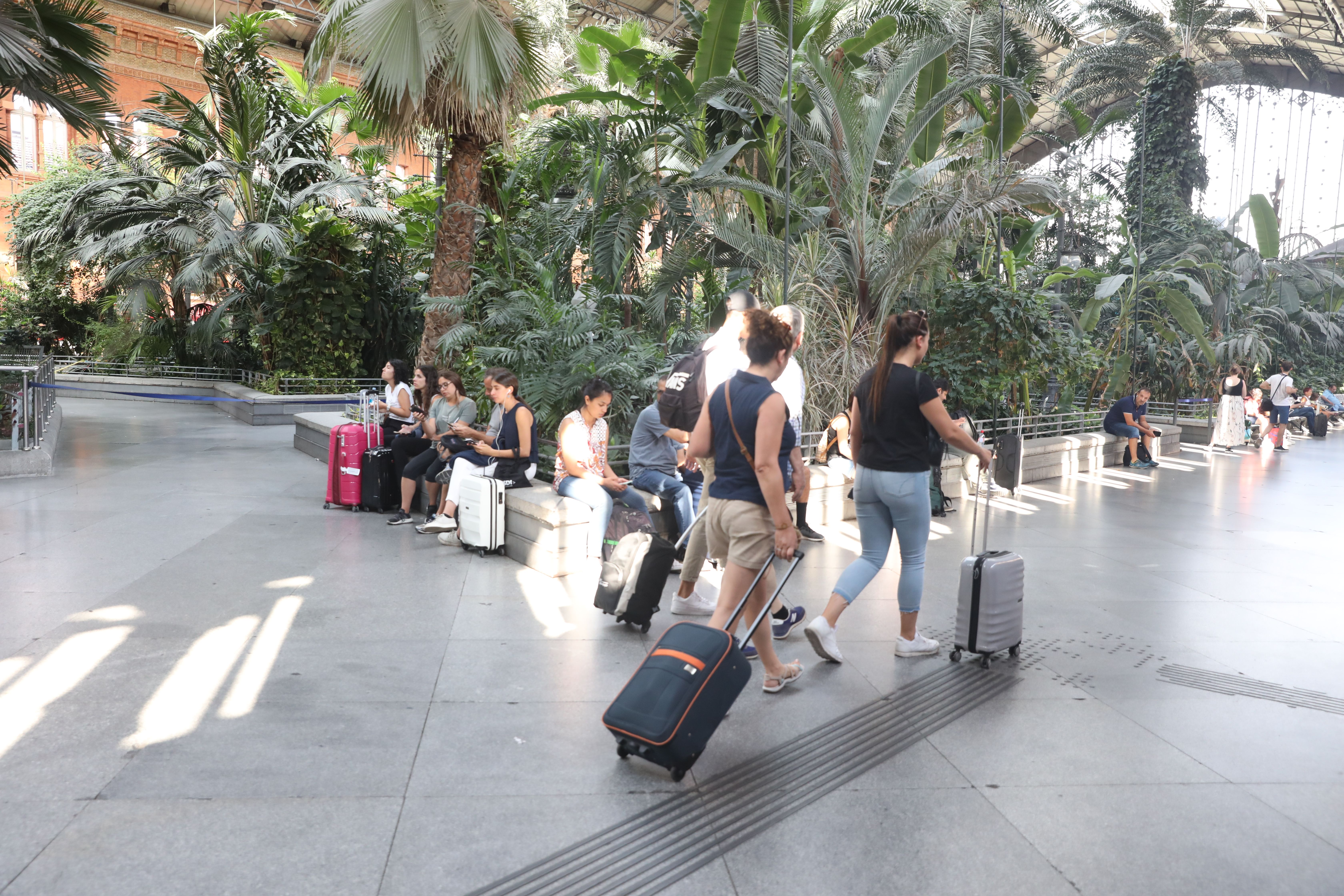 EuropaPress 2299628 Pasajeros en la estación de tren Puerta de Atocha de Madrid esperan con sus maletas en el Jardín Invernadero de la estación durante la primera de las cuatro jornadas de paros parciales de Renfe a los que el sindicato 