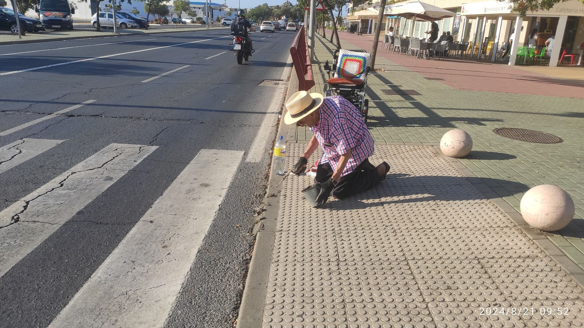Un hombre mayor de Aljaraque (Huelva) arregla un bordillo para poder pasar con su silla de ruedas Un hombre mayor de Aljaraque (Huelva) arregla un bordillo para poder pasar con su silla de ruedas