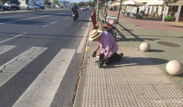 Un hombre mayor de Aljaraque (Huelva) arregla un bordillo para poder pasar con su silla de ruedas