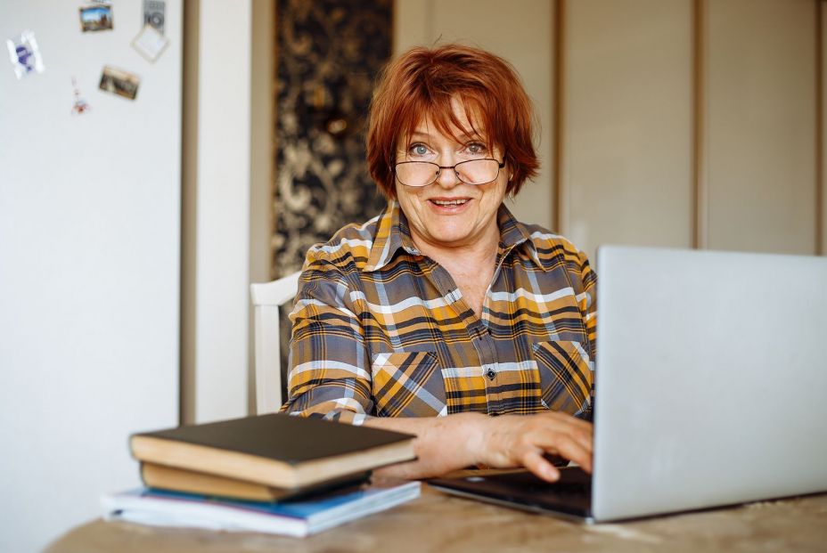 bigstock Happy Mature Lady Typing On La 454622991