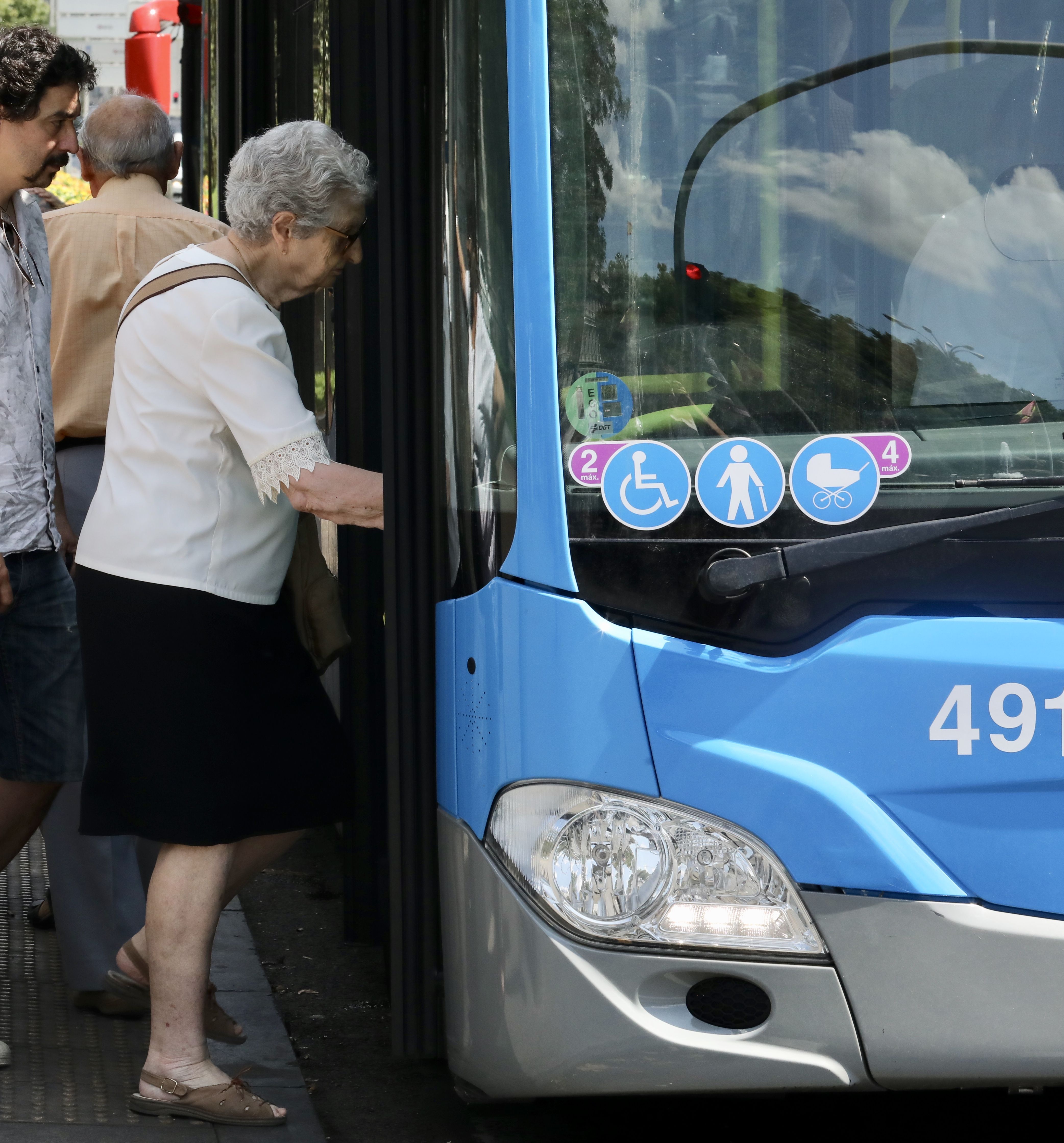 Una mujer de la tercera edad sube a un autobús de la EMT 