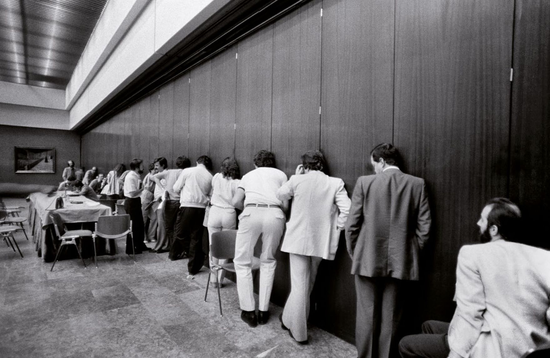 Marisa Flórez: 'Periodistas concentrados en busca de información durante una reunión a puerta cerrada del Consejo político de la UCD'. Madrid, 1982 Marisa Flórez: 'Periodistas concentrados en busca de información durante una reunión a puerta cerrada del Consejo político de la UCD'. Madrid, 1982