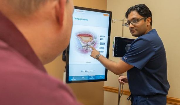 El Dr. Amin muestra la imagen de alargamiento de próstata al paciente Golden. (Orlando Health)