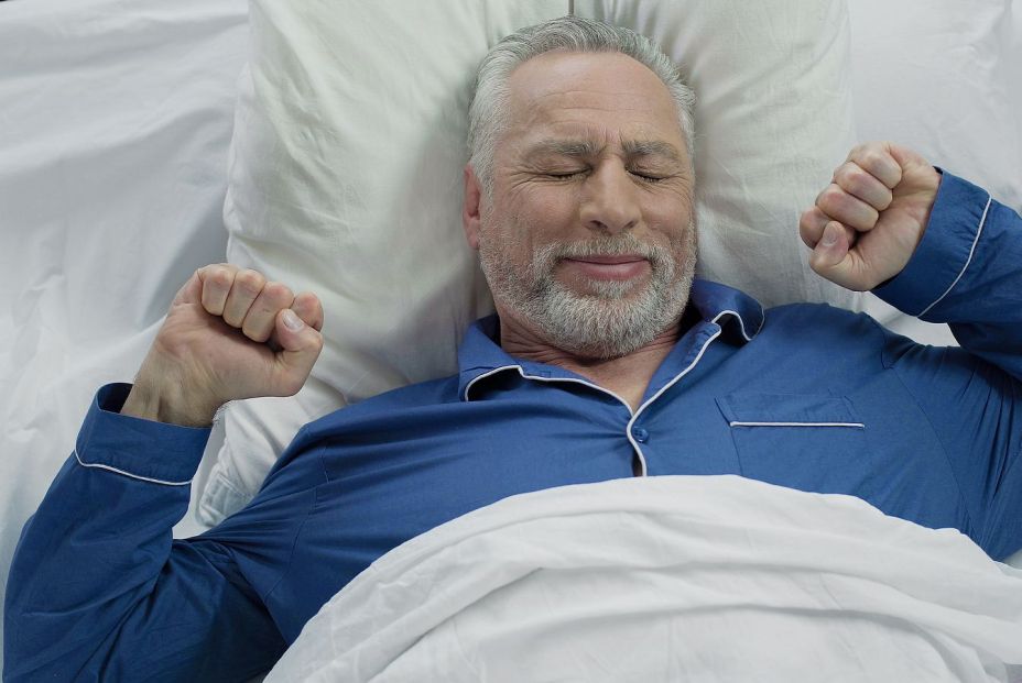 Un senior, estirándose tras una buena noche de sueño. (Bigstock)