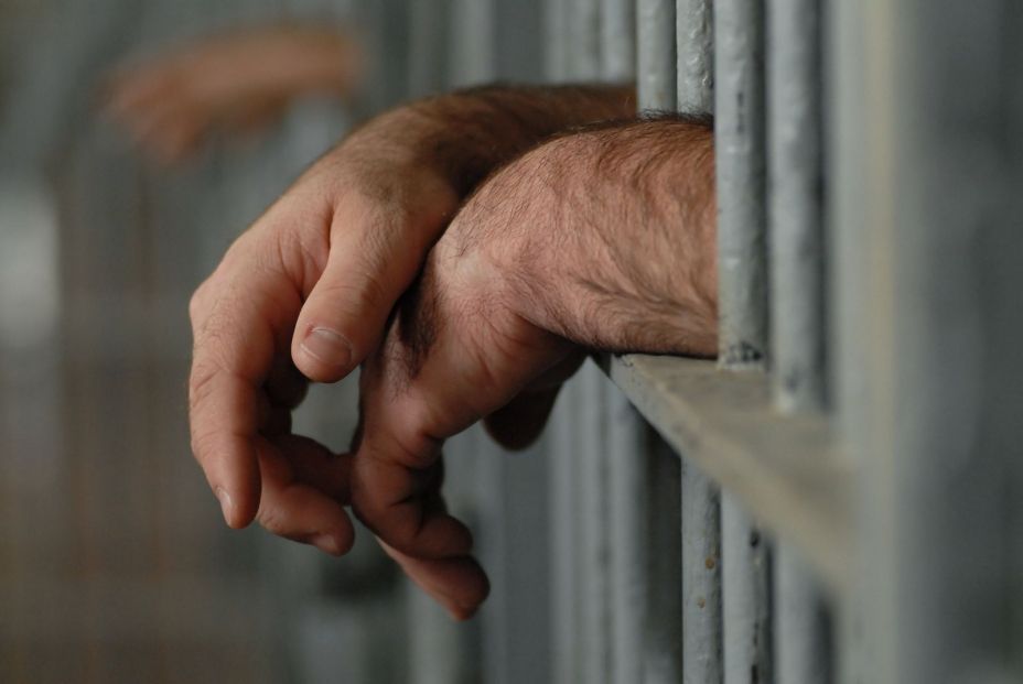 bigstock Hands Behind Bars 4796934 (1)