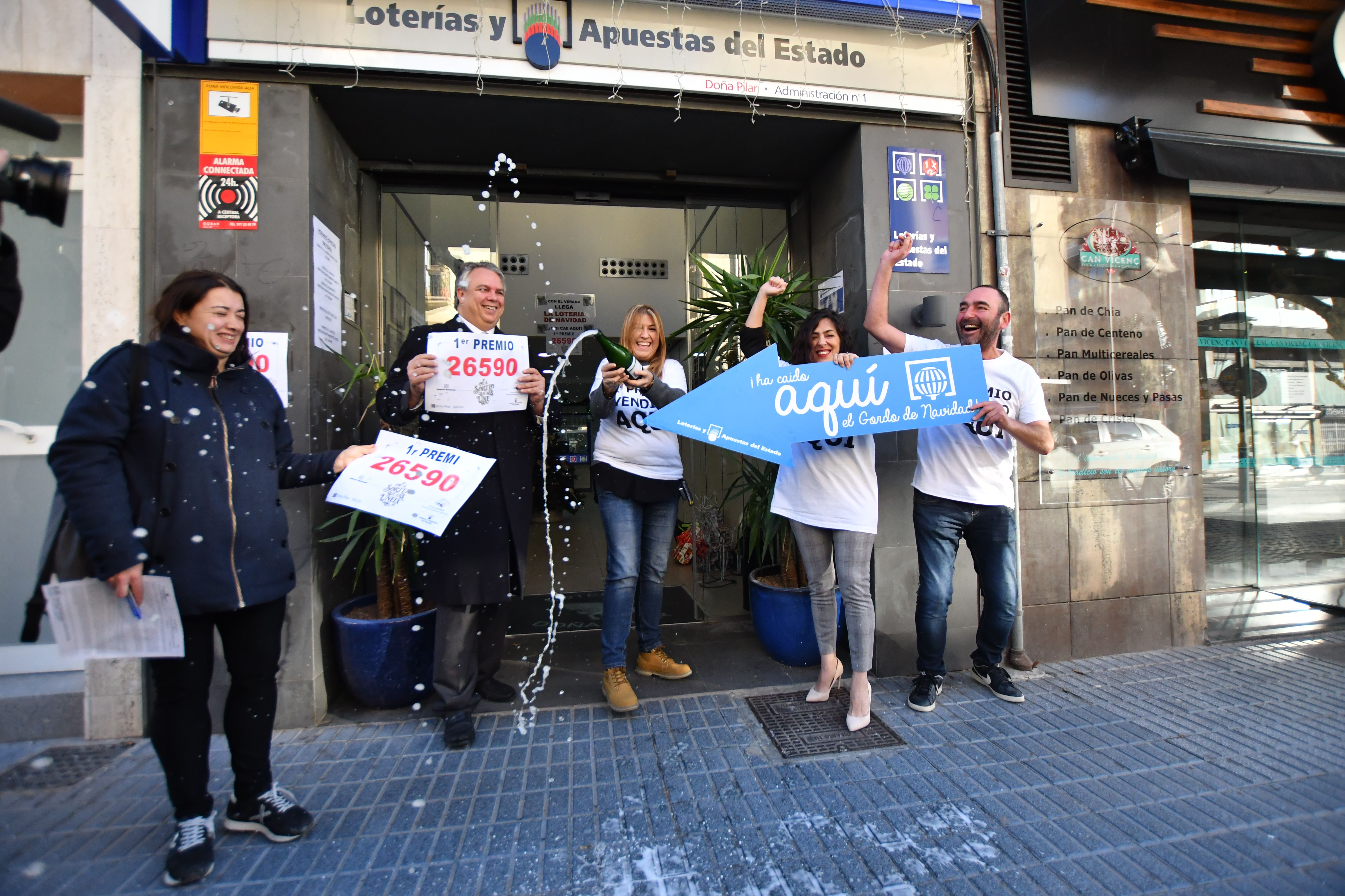 Reme Paredes (3i) y David Maiques (1d), los dueños de la administración de Lotería situada en la calle Barcelona, 10 de la localidad tarraconense de Salou, donde se ha vendido gran parte del número 26590 correspondiente a 'El Gordo'