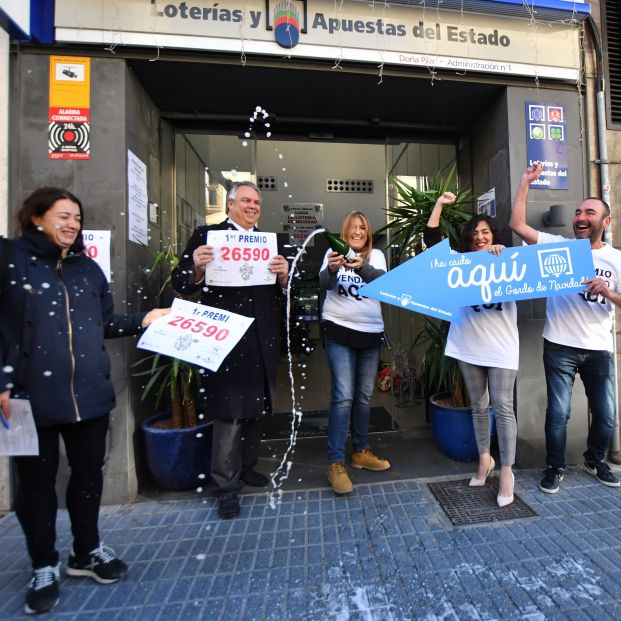 Reme Paredes (3i) y David Maiques (1d), los dueños de la administración de Lotería situada en la calle Barcelona, 10 de la localidad tarraconense de Salou, donde se ha vendido gran parte del número 26590 correspondiente a 'El Gordo'