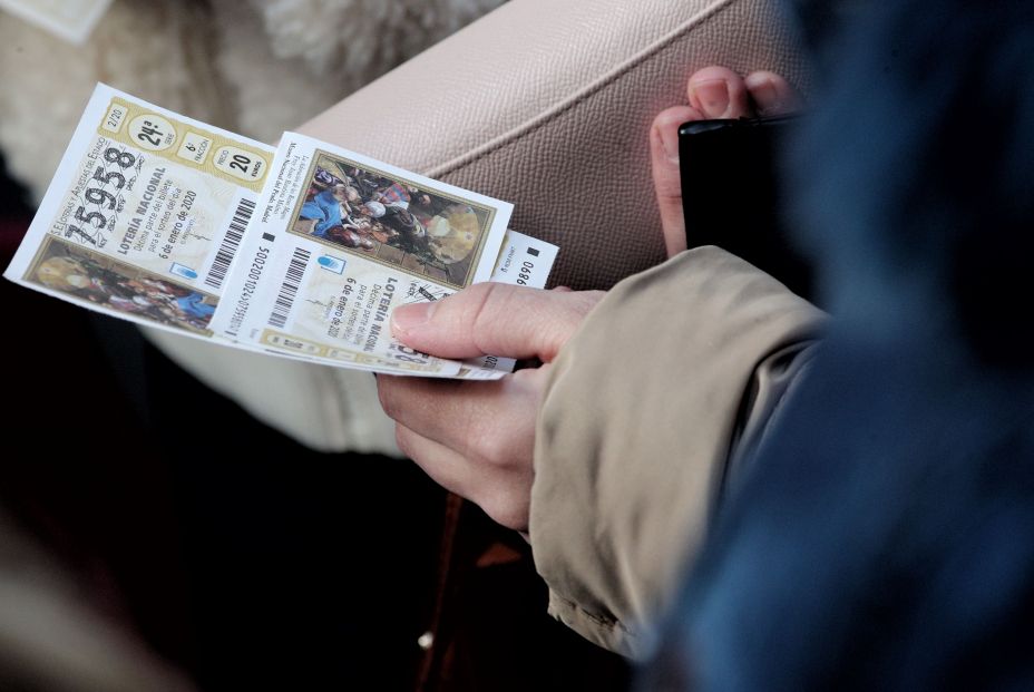 Una mujer compra varios boletos de la Lotería del Niño 