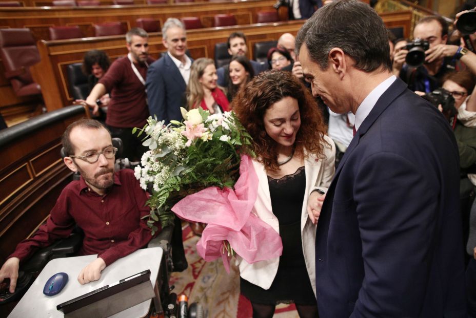 El presidente del Gobierno Pedro Sánchez (dech) saluda a la diputada de Unidas Podemos Aina Vidal la cual ha recibido de los miembros de su partido un ramo de flores en apoyo por el reciente diagnóstico de su enfermeda