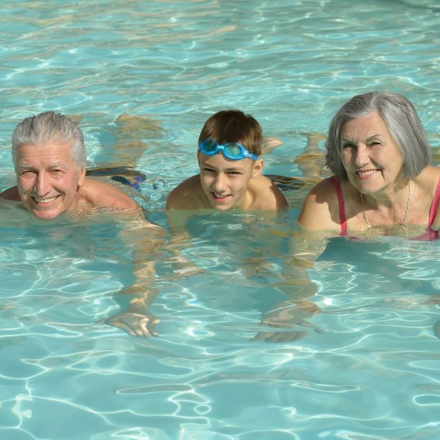 Abuelos y nietos hacen deporte en la piscina
