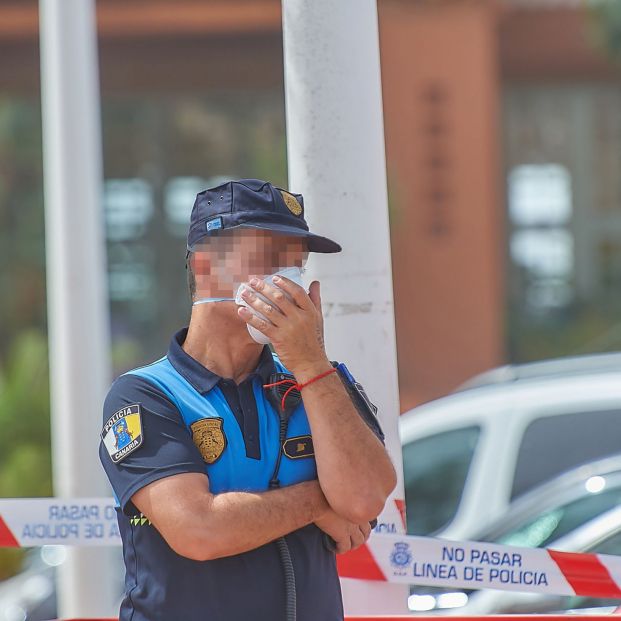 Un policía se protege con una mascarilla mientras custodia el Hotel H10 Costa Adeje Palace donde permanecen más de mil turistas aislados y custodiados por Policía Nacional al ser el lugar donde