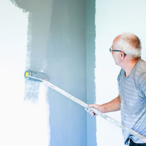 bigstock An Elderly Man Paints A Wall W 318471889