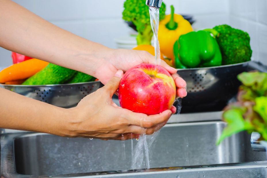 bigstock Young Woman Washing Lettuce An 323889877