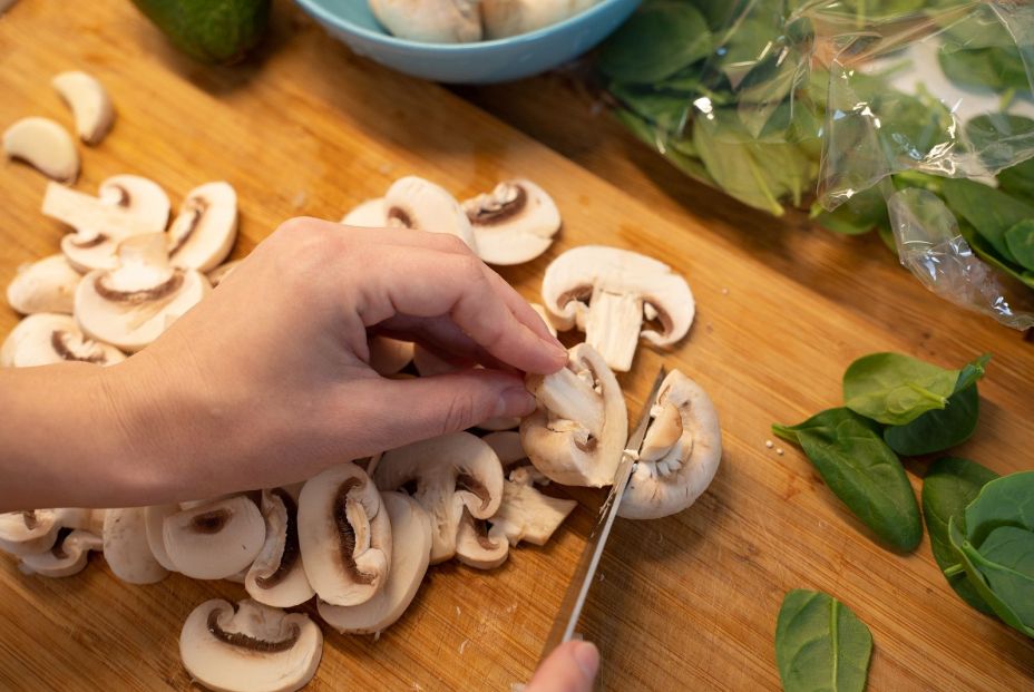 bigstock Woman Cutting Mushroom On Tabl 369018499