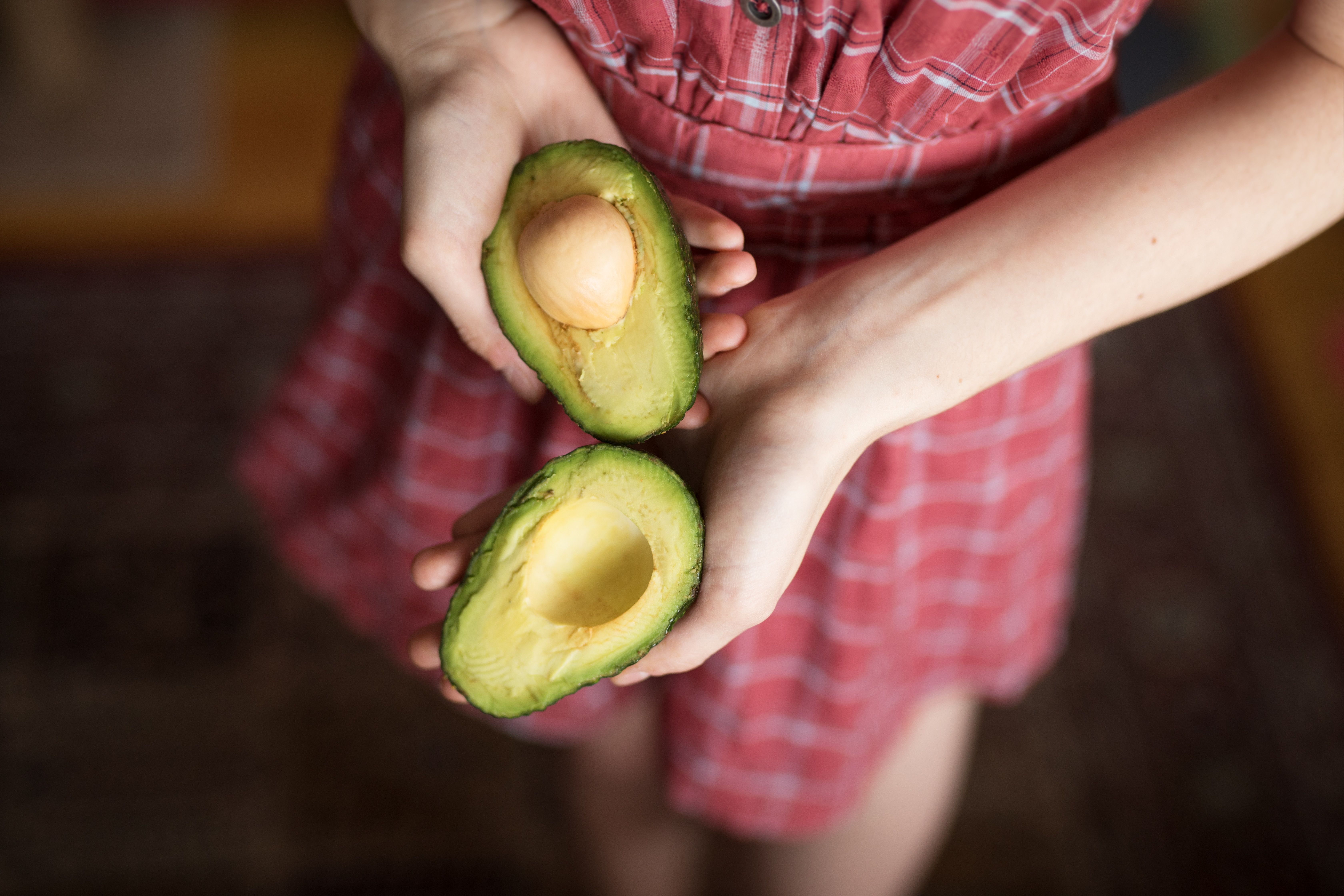 Mujer sujeta un aguacate. (bigstock)