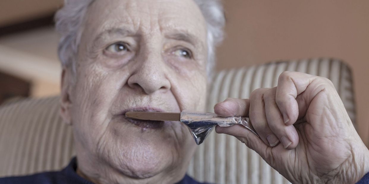 bigstock Senior Woman Eating A Chocolat 268138450
