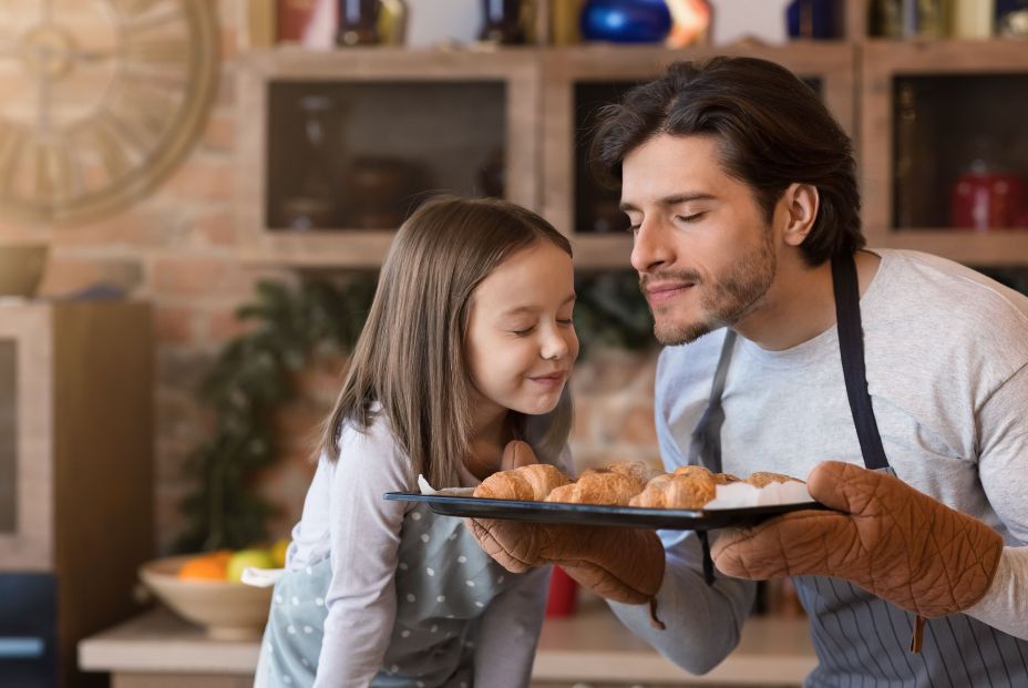 Padre e hija oliendo comida. Padre e hija oliendo comida.