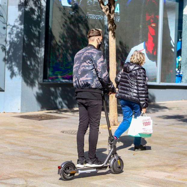 Un joven paseando con un patinete en la céntrica calle Fuencarral (Madrid), en octubre de 2020 (EuropaPress)