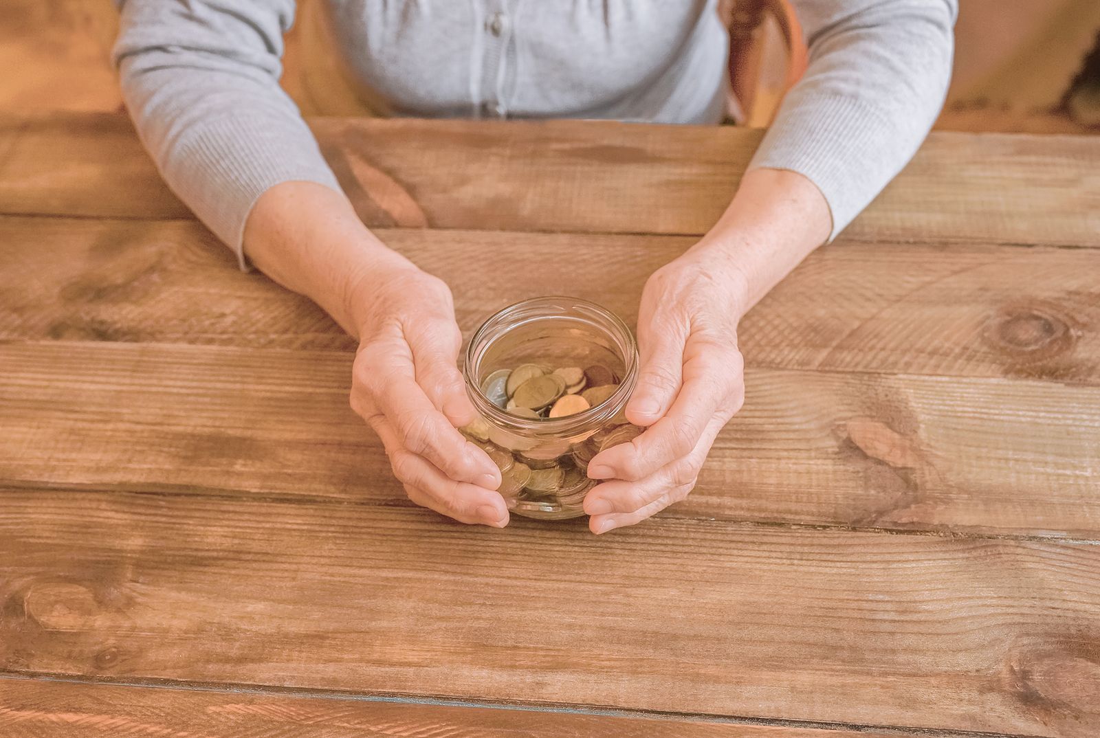 bigstock Old Wrinkled Hands Holding Jar 374114398