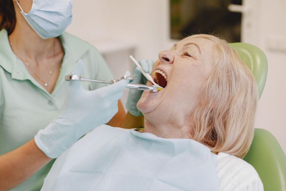 bigstock Dentist Looking Her Old Patien 396437966