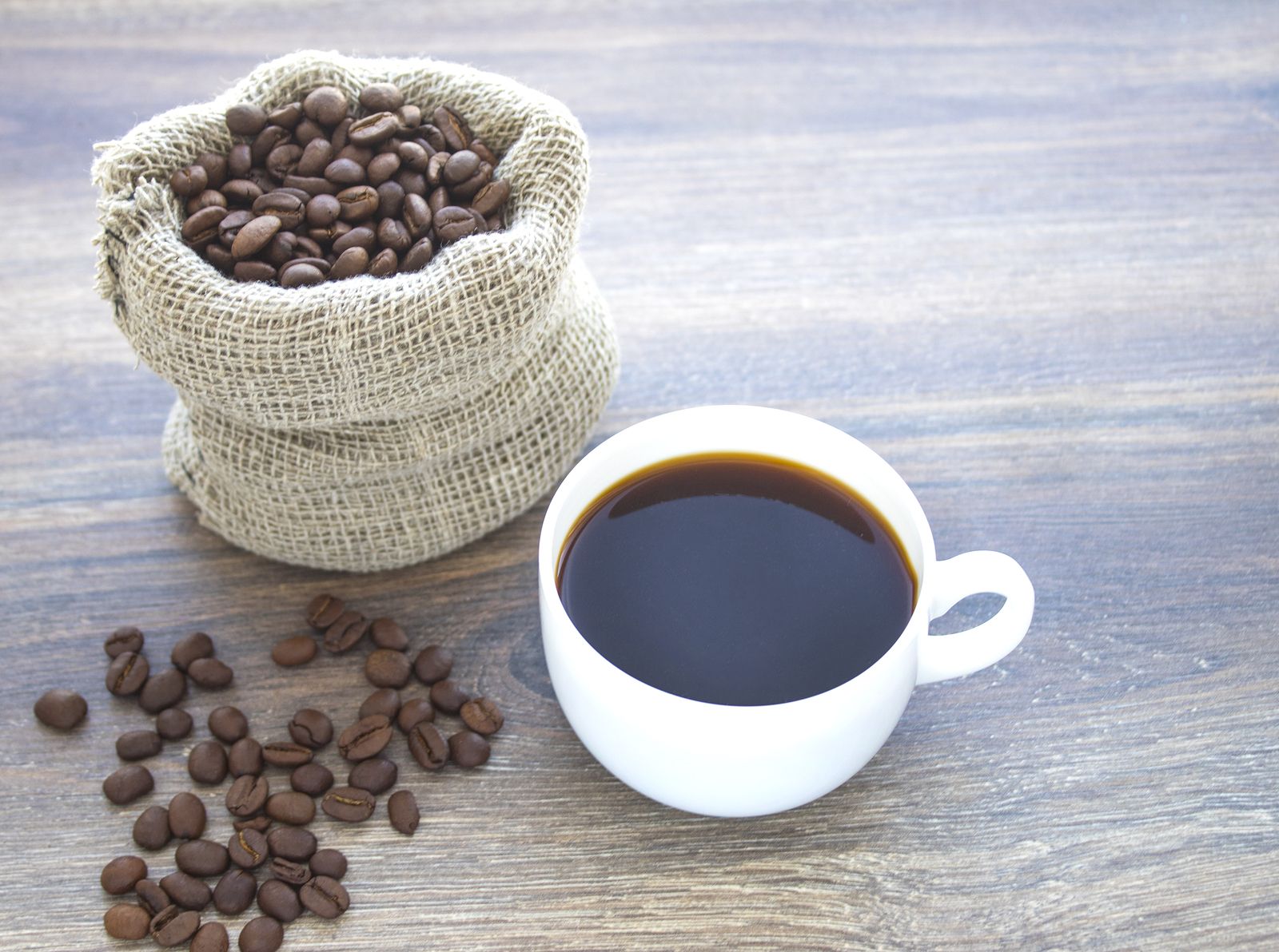 Una taza y granos de café (bigstock)