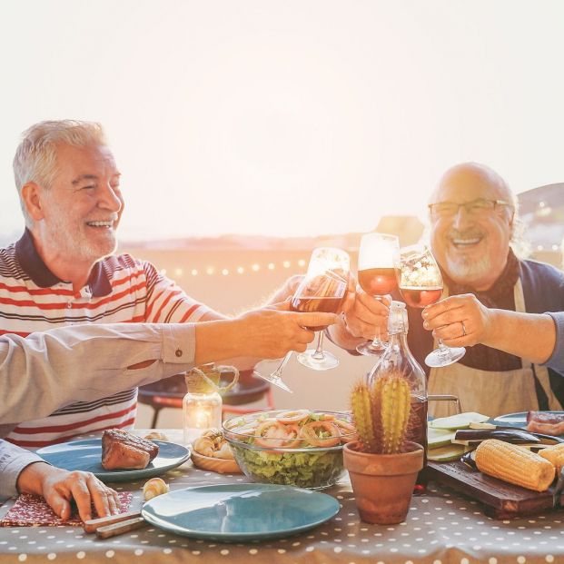 Personas mayores comiendo en grupo felices