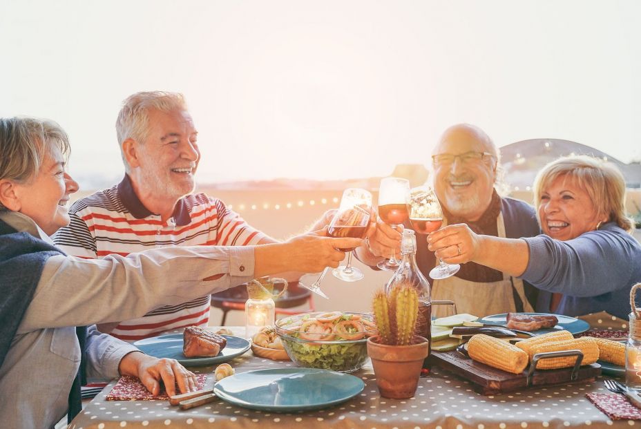 Personas mayores comiendo en grupo felices