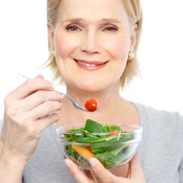 Mujer comiendo vegetales (bigstock)