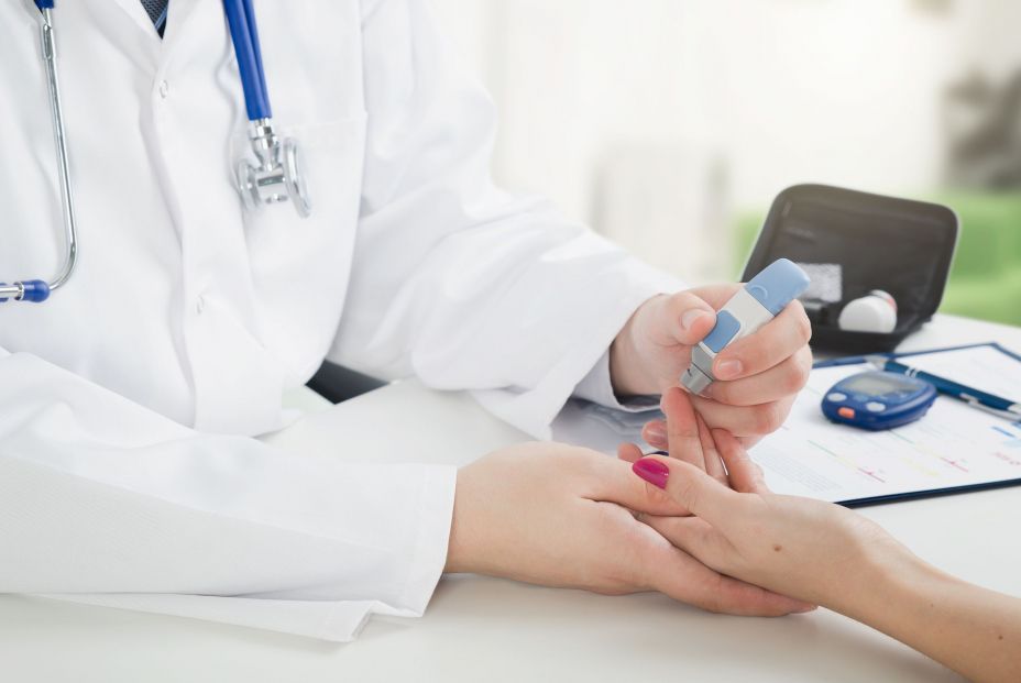 Doctora haciendo la prueba de diabetes a una paciente Doctora haciendo la prueba de diabetes a una paciente