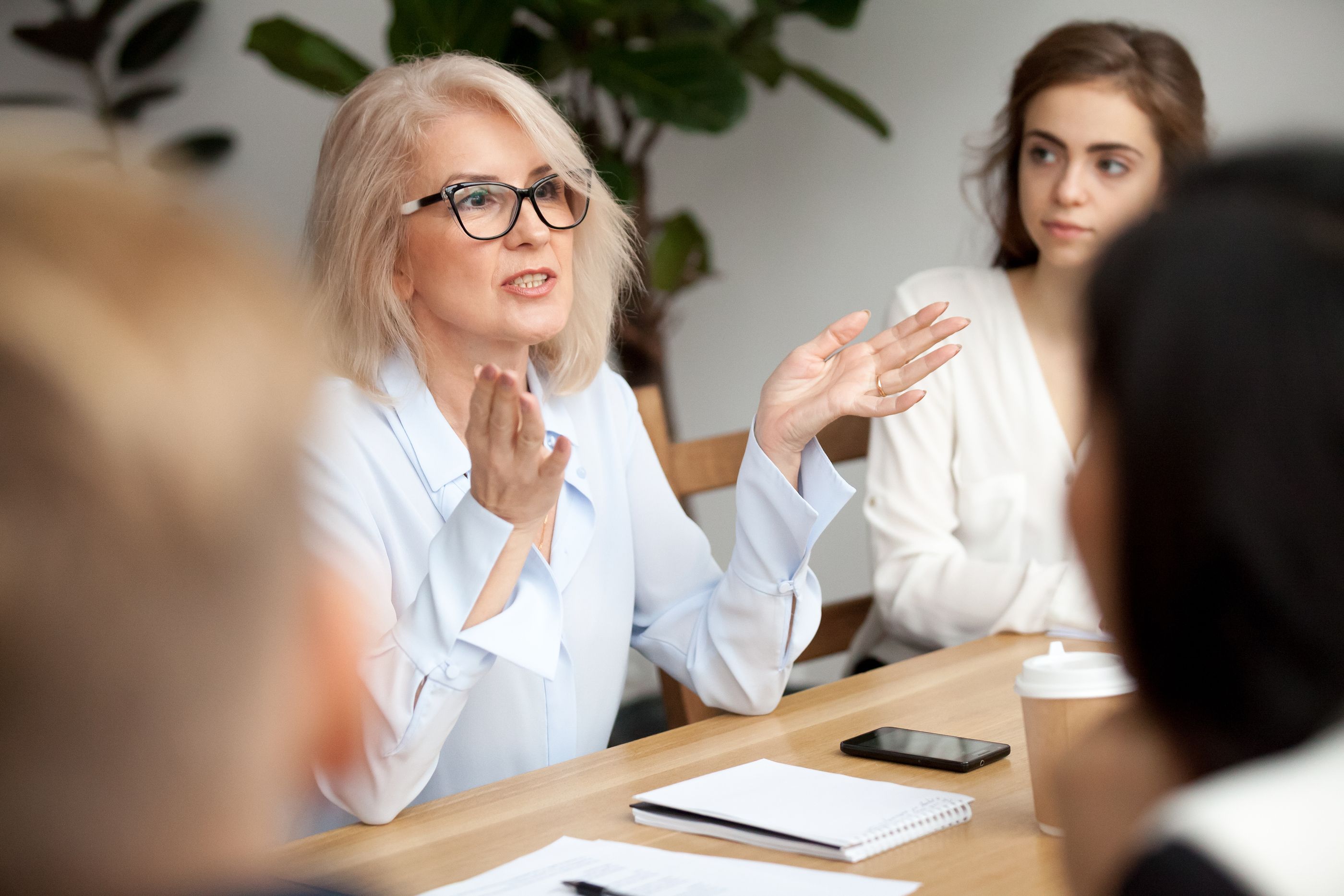 Sócrates café: Mujer hablando ante un grupo de personas (Bigstock)