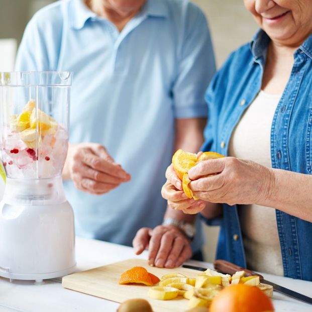 Pareja preparando un batido de frutas