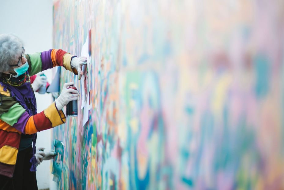 Una de las 'abuelas grafiteras' decorando una pared con una plantilla