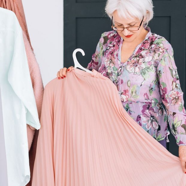 Mujer cogiendo ropa del armario Mujer cogiendo ropa del armario